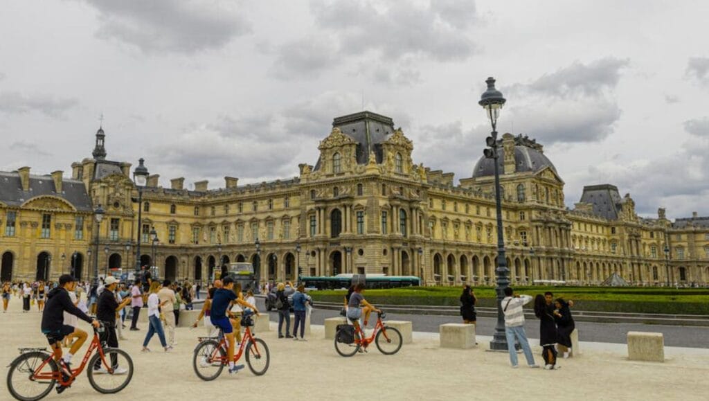 Paris on a Budget: How to Save Money Without Missing Out 2 Paris on a Budget - Bicyclists in front of the Louvre Museum, Paris